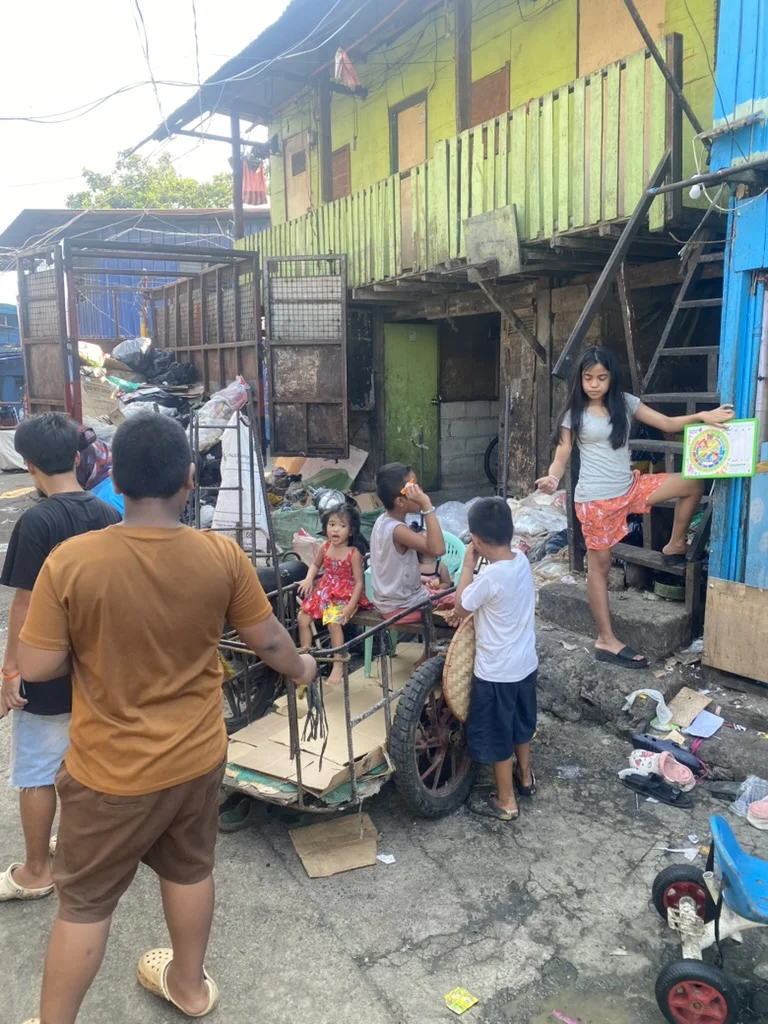 People standing in a lane beside two-storey homes.